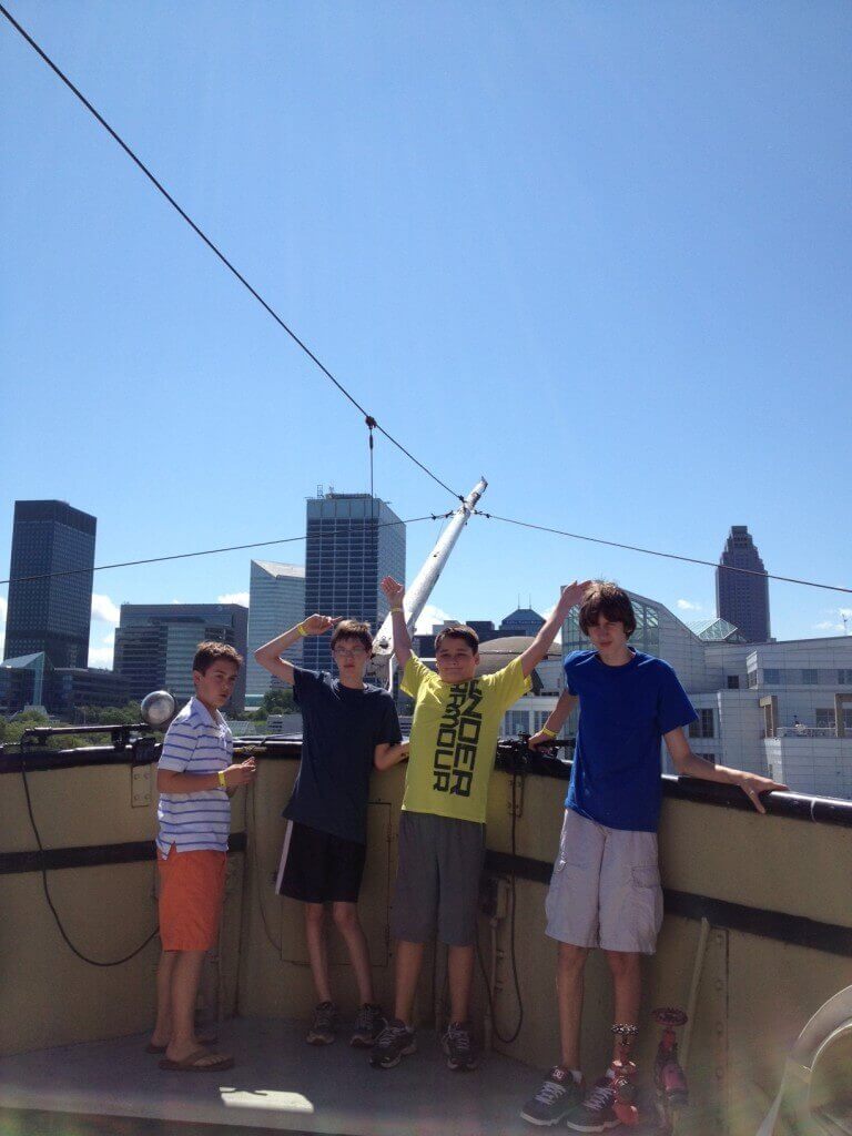 Four boys on rooftop with downtown skyline