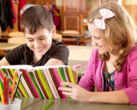 Boy and Girl Reading a Book Together