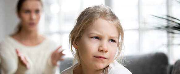 Child looks concerned during conversation with adult.