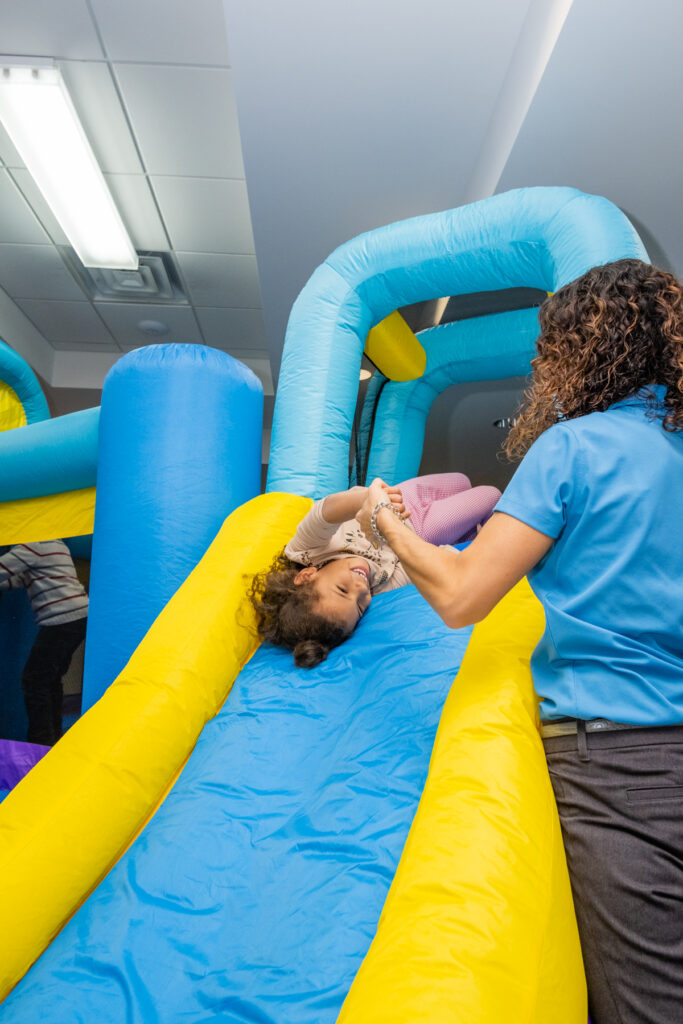 A girl sliding down the bouncy house