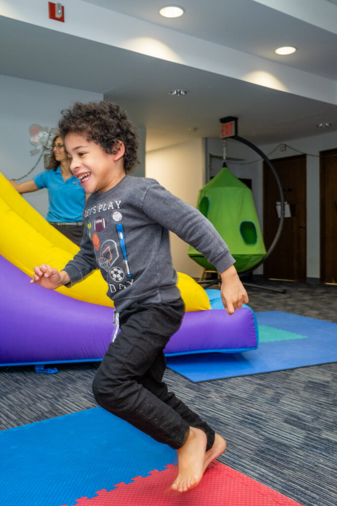 A kid running to the bouncy house