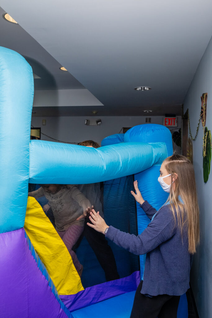Masked woman navigating indoor inflatable obstacle