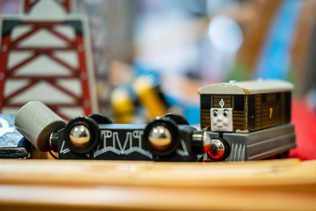 Toy train engine with wooden cargo car.