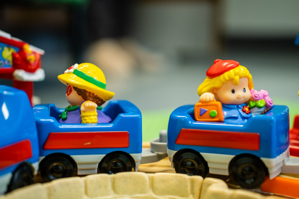 Colorful toy train with two smiling figures.