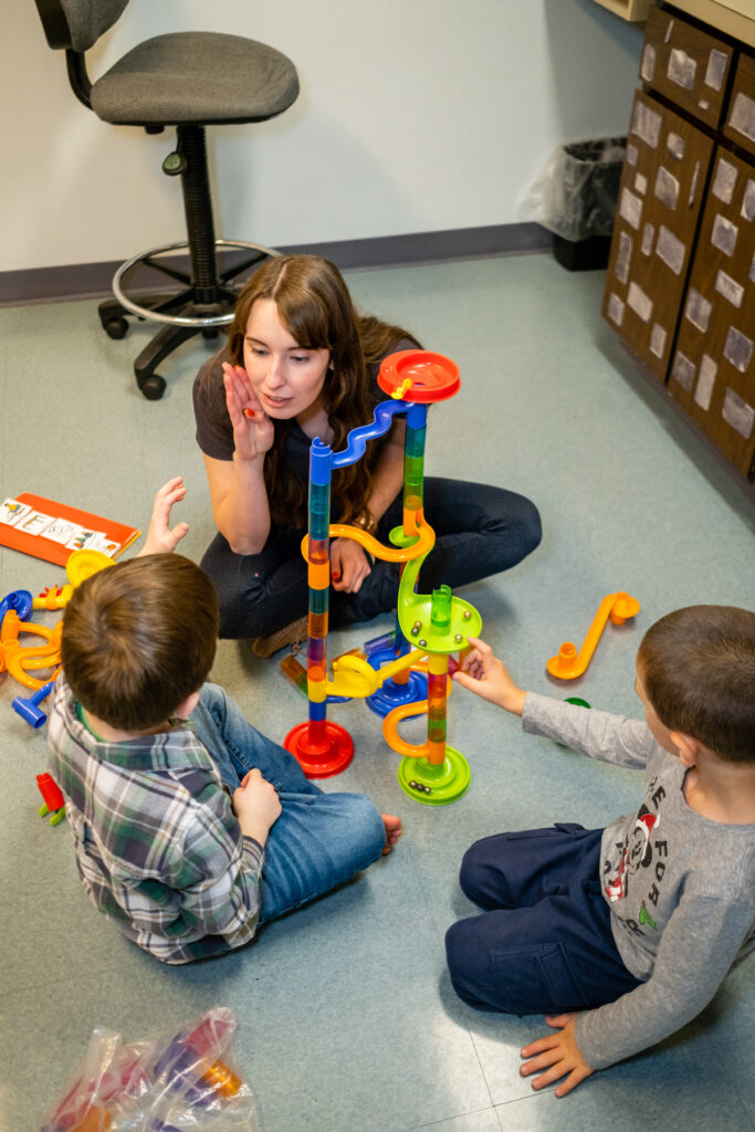 Two kids in therapy with a woman