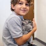 A kid holding a pet animal