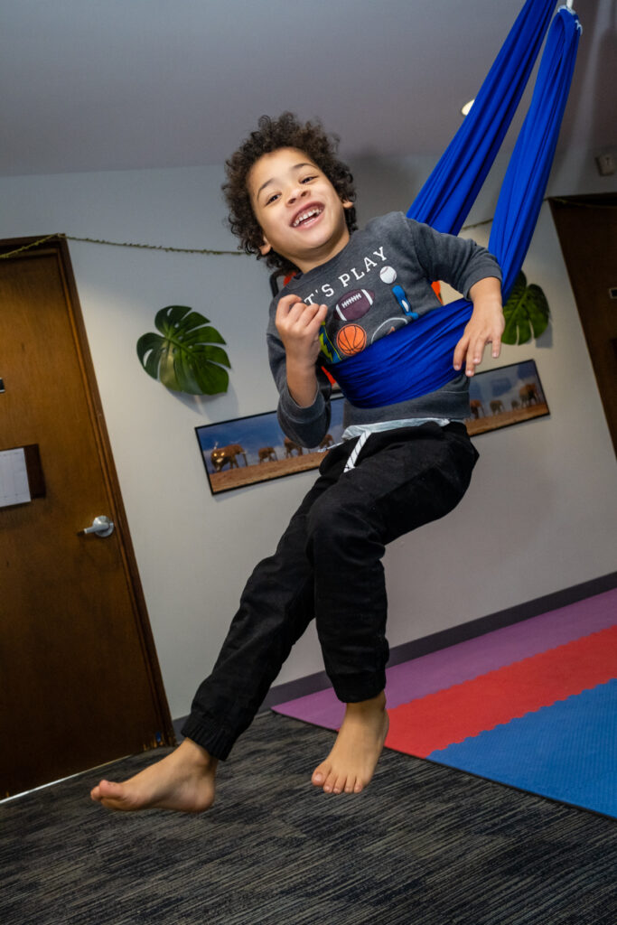 A kid using a swing for therapy