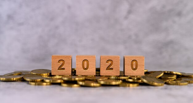 Wooden 2020 blocks on pile of gold coins